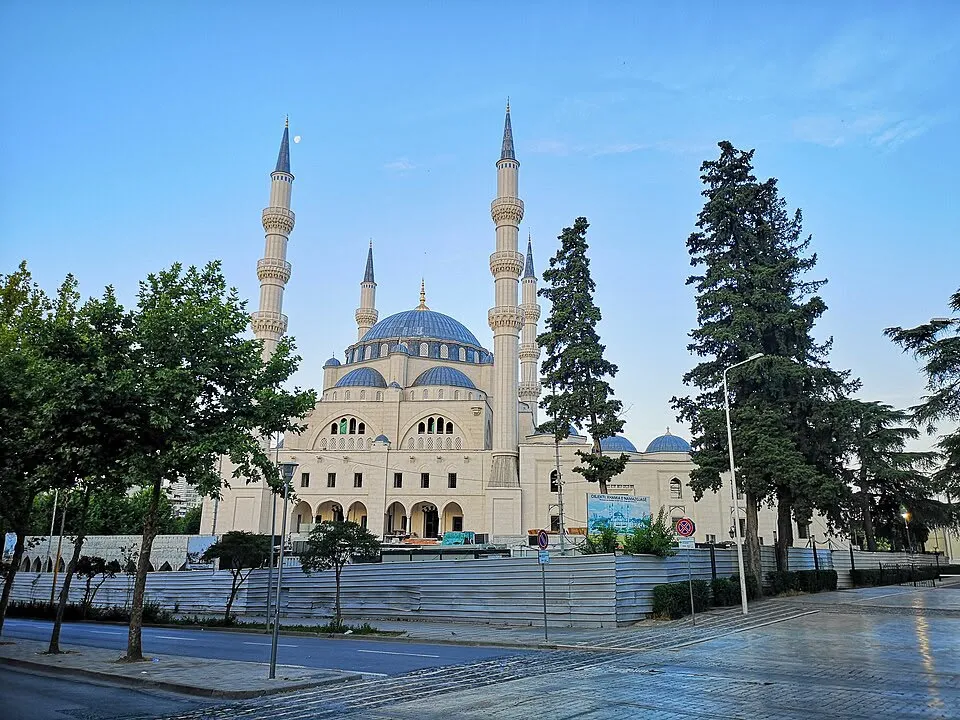 The Namazgah Mosque in Tirana, still surrounded by construction hoardings, with its four minarets and blue dome